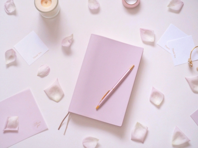 ピンクのノートとペン、花びら